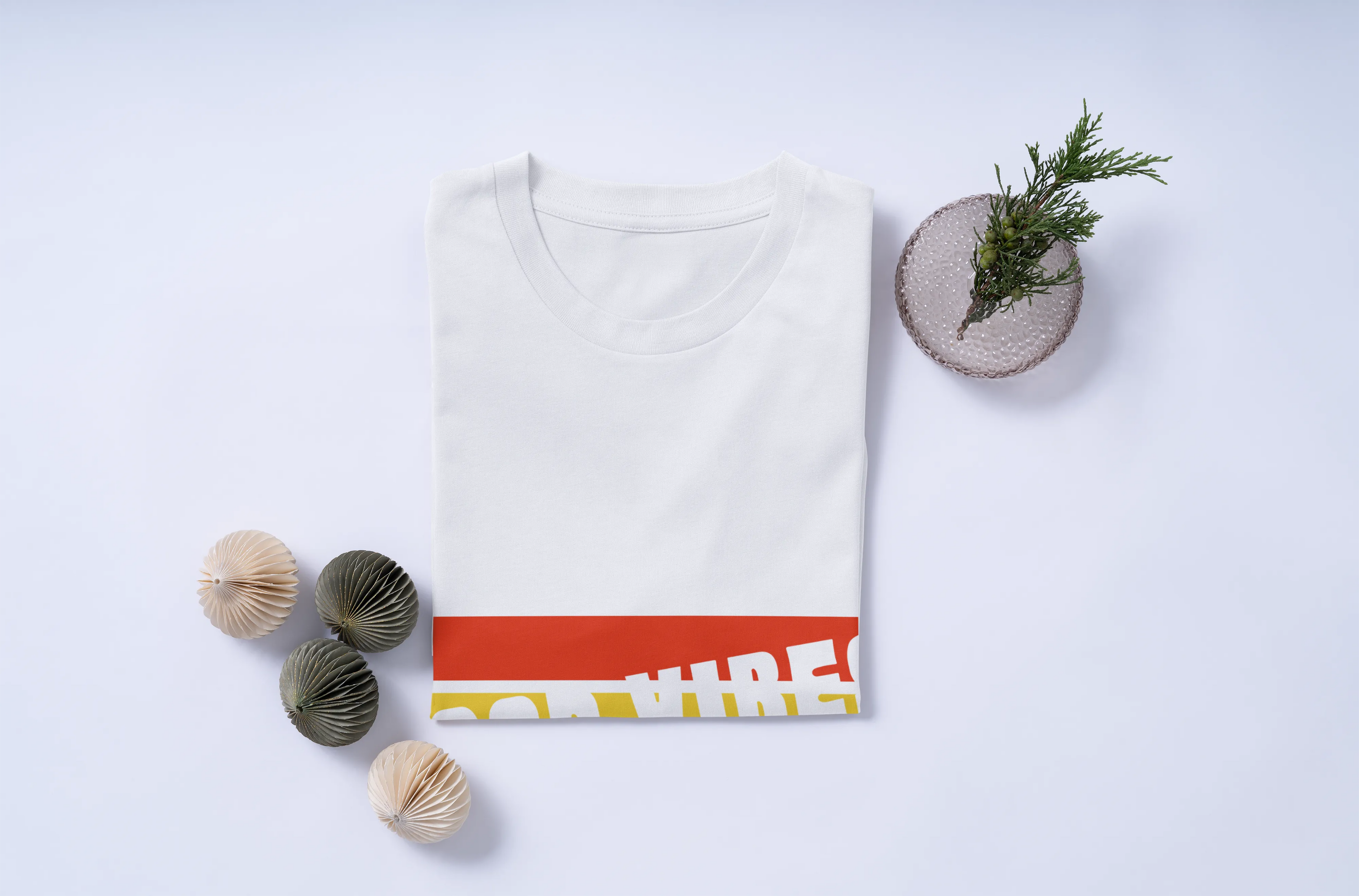 White t-shirt with red and yellow design on a light gray background