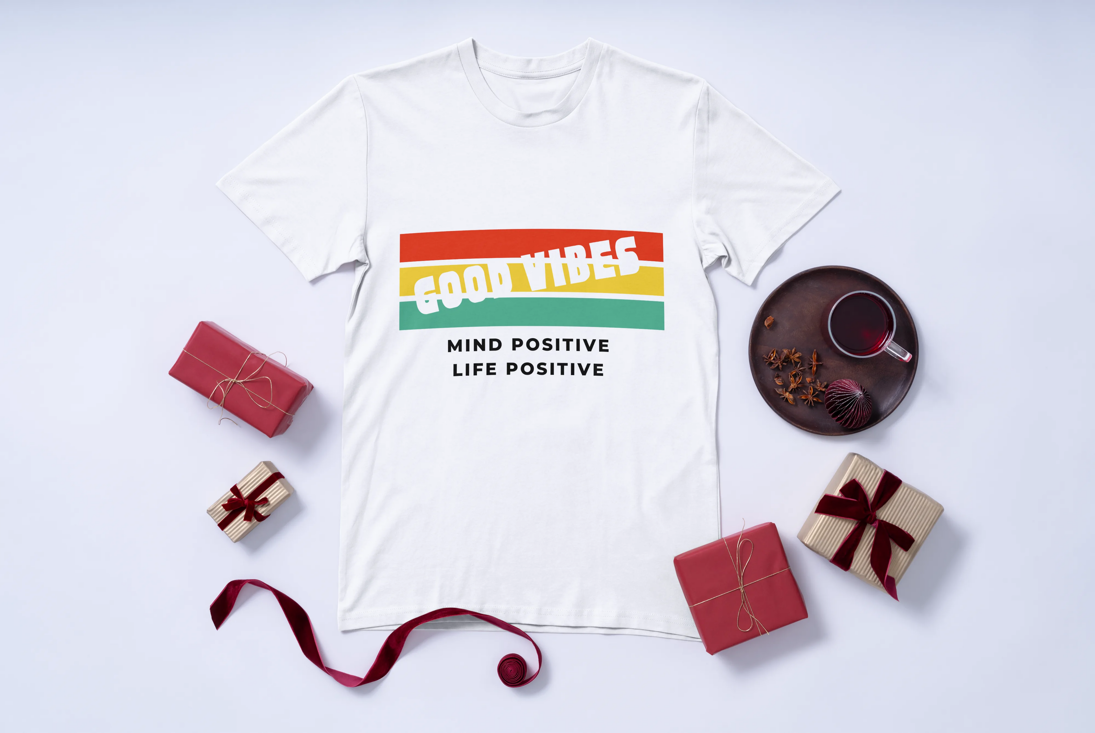 White t-shirt with motivational quote on a white background with decorative items around